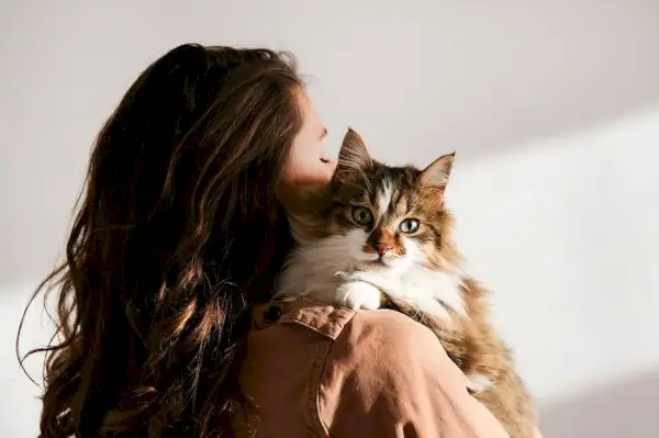 L’image capture un moment émouvant d’une femme serrant tendrement son chat dans ses bras.