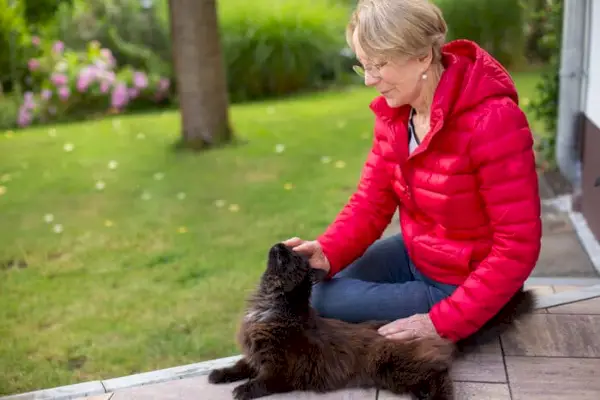 Une personne qui cherche dehors avec une expression inquiète, probablement à la recherche d'un chat perdu.