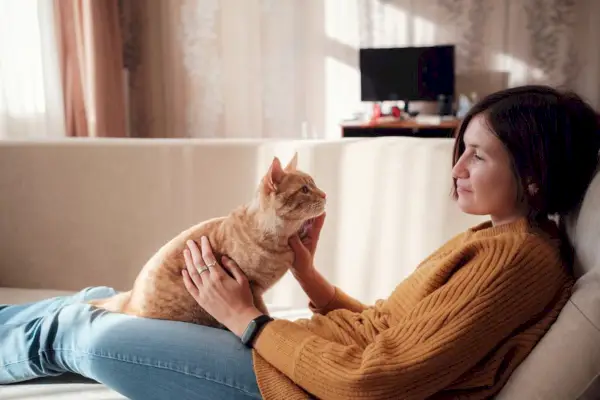 femme se reposant avec un animal de compagnie dans un canapé