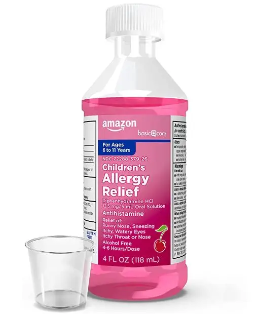 bottle of liquid Benadryl with a little container to contain and administer the liquid