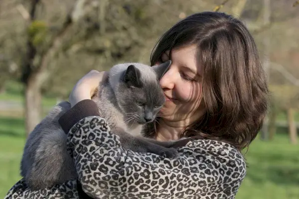 gato feliz con los ojos cerrados abraza al dueño