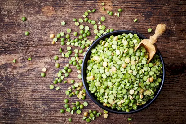 Tazón de guisantes verdes sobre fondo de madera