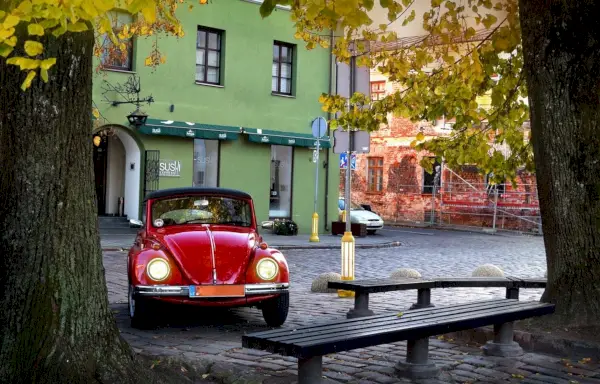 Rotes Oldtimer, das im Schatten geparkt ist