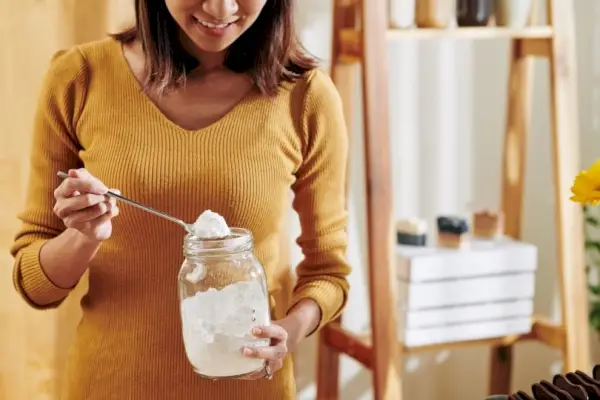 femme tenant un pot de bicarbonate de soude