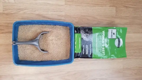 Bolsa de arena para gatos natural Almo Nature junto a una caja de arena llena