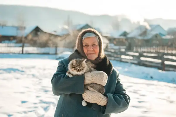 Rusė močiutė ant rankų laiko kačiuką